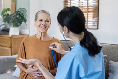 Doktor, kalp atışlarını kontrol etmek için emeklilik yaşının kalp atışlarını dinliyor..