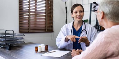 Kadın doktor, yaşlı hastalara günlük olarak tavsiye ve vitamin vermektedir..