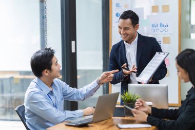 Genç iş adamı temsilcisi, çeşitli iş adamlarına toplantıda sunum yapacak. İşadamı çeşitli meslektaşlarına beyaz tahtada proje sundu.