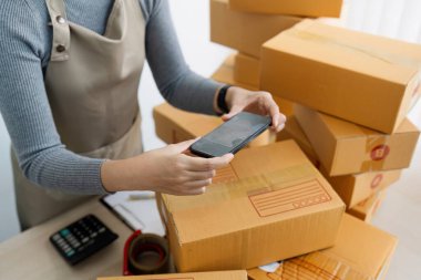 Telefon uygulaması ile detayların fotoğrafını çekerek internet üzerinden satmak ve nakliye kutularıyla evde e-ticaret yapan kadınlar..