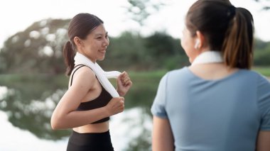 Güneşin doğuşuna koşan iki mutlu kadın. Parkta koşan eşofmanlı kadınlar.