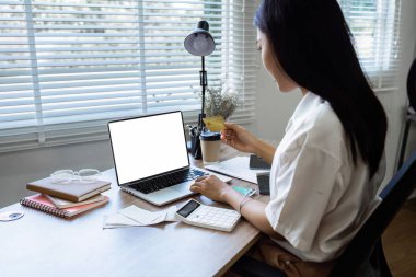 Genç bir kadın internette kredi kartıyla bir şeyler satın alıyor..