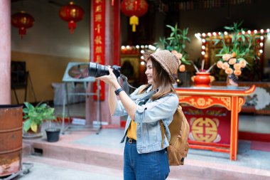 Genç Asyalı kadın bir sırt çantası gezgini kamera kullanıyor. Yolculuk hayat tarzı. seyahat kavramı.