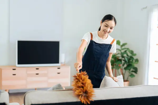 Young Woman happy to house and cleaning sofa at Livingroom on weekend. cleaning concept.