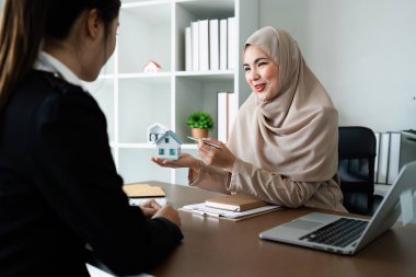 Emlakçı ve müşteri sözleşme imzalamadan önce emlak sigortası ve güvenlik konsepti hakkında konuşuyorlar..