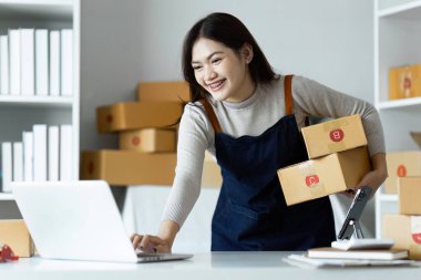 Dizüstü bilgisayar kullanan genç bir girişimci. Nakliyeye, çevrimiçi satışa, e-ticaret konseptine hazırlık.