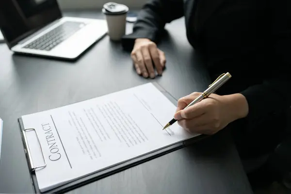 Businesswoman signing a document for approve with partner in a folder.