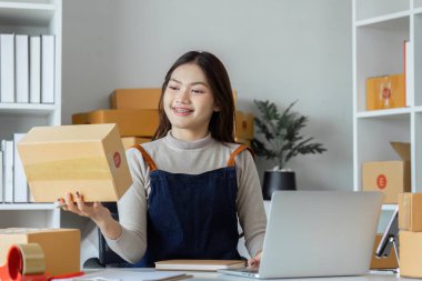 Dizüstü bilgisayar kullanan genç bir girişimci. Nakliyeye, çevrimiçi satışa, e-ticaret konseptine hazırlık.