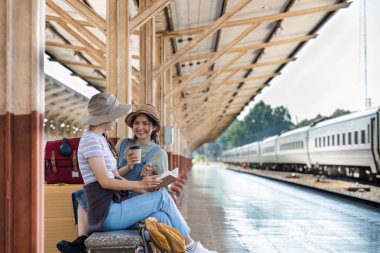 Tren istasyonundaki Asyalı kadınların mutlu anları olur. Turizm ve seyahat.