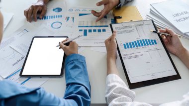 İş adamları dijital tablet kullanıyor ve toplantı odasında proje üzerinde birlikte çalışıyorlar.