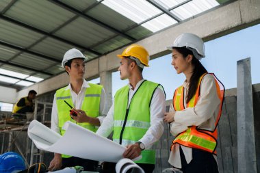 Mühendis, ustabaşı, mimar iş arkadaşları için inşaat planlarını tartışan ve kontrol eden bir toplantı..