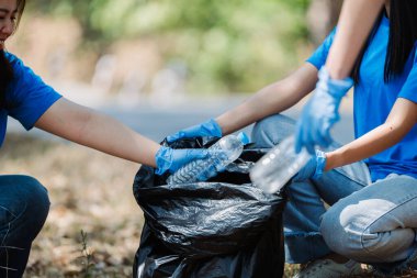 Geri dönüşüm için doğayı çöplerden ve plastik atıklardan temizleyen gönüllüler ve topluluk üyeleri..