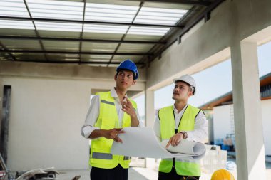 Mühendis, ustabaşı, mimar iş arkadaşları için inşaat planlarını tartışan ve kontrol eden bir toplantı..