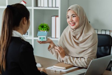 Emlakçı ev satın alma anlaşmasının şartları hakkında konuştu ve müşteriden sözleşmeyi yasal hale getirmek için belge imzalamasını istedi..