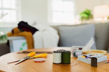 Makaralar, iş parçacığı ve iğneleri, iğne, yüksük ve mezura gibi temel dikiş araçları.