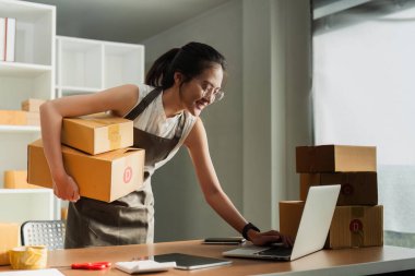 Dizüstü bilgisayar kullanan genç bir girişimci. Nakliyeye, çevrimiçi satışa, e-ticaret konseptine hazırlık.