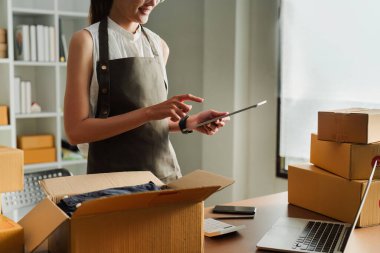 Dizüstü bilgisayar kullanan genç bir girişimci. Nakliyeye, çevrimiçi satışa, e-ticaret konseptine hazırlık.