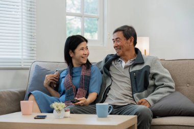 Rahatlayın, ev ve olgun çiftler kanepeye kurulun sağlıklı bir ilişki ve evlilik için sarılın. Emeklilik, mutlu.