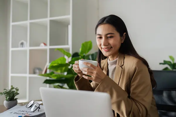 Gülümseyen Kadını Kahve Içiyor Yeşil Modern Ofiste Dizüstü Bilgisayarla Çalışıyor — Stok fotoğraf