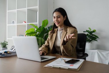 İş kadını girişimci iş yerinde dizüstü bilgisayar kullanıyor, işyerinde bilgisayarla çalışan takım elbiseli, gülümseyen profesyonel kadın şirket yöneticisi.