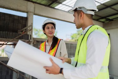 Mühendis, ustabaşı, mimar iş arkadaşları için inşaat planlarını tartışan ve kontrol eden bir toplantı..