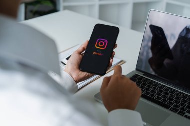 CHIANG MAI, THAILAND - 20 Mart 2024: Bir kadın ekranda Instagram uygulamalı Apple iPhone 'u tutuyor. Instagram akıllı telefonlar için fotoğraf paylaşım uygulamasıdır.