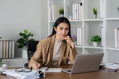 İş kadını girişimci iş yerinde dizüstü bilgisayar kullanıyor, işyerinde bilgisayarla çalışan takım elbiseli, gülümseyen profesyonel kadın şirket yöneticisi.