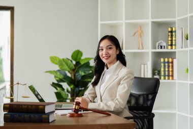 Woman lawyer confident working about ducument at desk and looking at camera. clipart