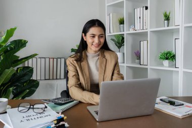 İş kadını girişimci iş yerinde dizüstü bilgisayar kullanıyor, işyerinde bilgisayarla çalışan takım elbiseli, gülümseyen profesyonel kadın şirket yöneticisi.