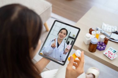 Son sınıf Asyalı kadın videosu, tabletteki doktorla görüşme sağlık sorunları ve internetten ilaç tedavisi. Doktor teletıp kavramı.