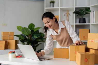 Dizüstü bilgisayar kullanan genç bir girişimci. Nakliyeye, çevrimiçi satışa, e-ticaret konseptine hazırlık.