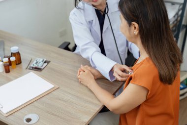 Kardiyologla sağlık kontrolü olan mutlu yaşlı bir hasta. Kardiyoloji için hastanede doktor kadın ve steteskop danışmanlığı.