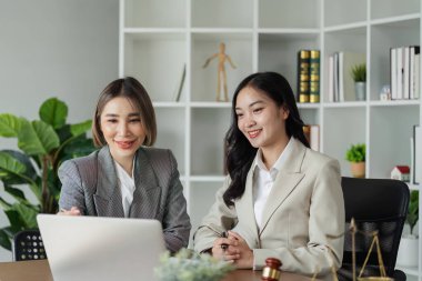 Avukat ve müvekkil laptopta veri tartışıyor, müşteriye laptopta iş konularında danışmanlık yapıyor.