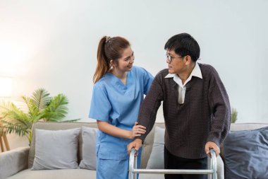 Hemşire ya da bakıcı yaşlılara evde Walker 'ı kullanarak yürümelerine yardım ediyor. Sağlık hizmetleri ev ziyareti kavramı.