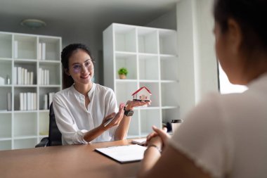 Emlakçı, emlak ve ev satış sözleşmesi ve ev sigortası konularını müşteriye açıklarken iş adamının sözleşmenin şartlarını sorduğunu söyledi..
