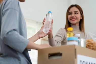 Hayır işi, bağış ve gönüllülük konsepti. Gönüllü, içinde yiyecek olan yiyecek kutusunu evdeki fakir, felaket mağdurlarına bağışlamak için hazırla..