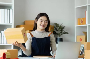 Dizüstü bilgisayar kullanan genç bir girişimci. Nakliyeye, çevrimiçi satışa, e-ticaret konseptine hazırlık.