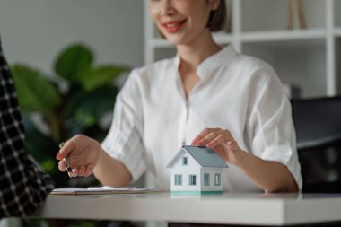 Emlakçı ev satın alma anlaşmasının şartları hakkında konuştu ve müşteriden belgeleri imzalamasını istedi..