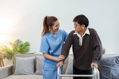 Hemşire ya da bakıcı yaşlılara evde Walker 'ı kullanarak yürümelerine yardım ediyor. Sağlık hizmetleri ev ziyareti kavramı.