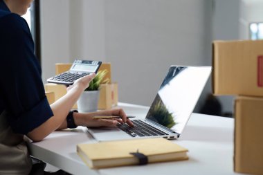 Dizüstü bilgisayar kullanan genç bir girişimci. Nakliyeye, çevrimiçi satışa, e-ticaret konseptine hazırlık.