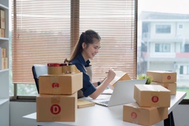 Dizüstü bilgisayar kullanan genç bir girişimci. Nakliyeye, çevrimiçi satışa, e-ticaret konseptine hazırlık.