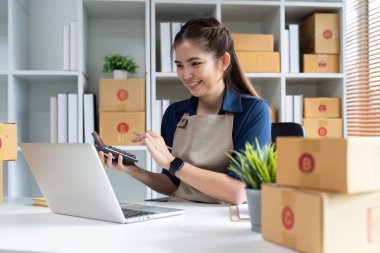 Dizüstü bilgisayar kullanan genç bir girişimci. Nakliyeye, çevrimiçi satışa, e-ticaret konseptine hazırlık.