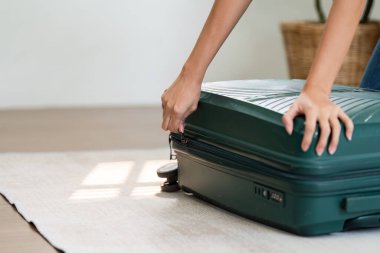 Genç bayan yere otur ve hafta sonu seyahati için bavul hazırla..