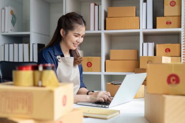 Dizüstü bilgisayar kullanan genç bir girişimci. Nakliyeye, çevrimiçi satışa, e-ticaret konseptine hazırlık.