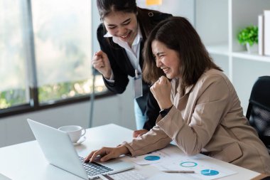 Modern bir ofiste başarılı bir projeyi kutlayan iki iş kadını takım çalışması ve profesyonel başarı sergilediler..