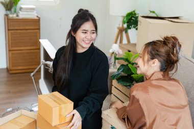 Neşeli lezbiyen çift yeni evlerinde kutuları açıyor, aşkı, yeni başlangıçları ve birlikte yaşamanın heyecanını sembolize ediyorlar..