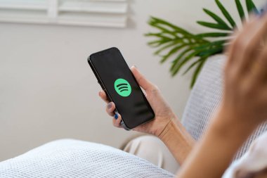 CHIANG MAI, THAILAND 25 Haziran 2024: Apple iPhone 13 Spotify uygulamalı akıllı telefon. Potify, size milyonlarca şarkıya erişim imkanı veren dijital bir müzik servisidir.