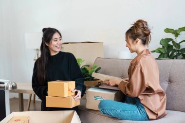 Lezbiyen çift sevinçle yeni evlerinde kutuları açıyor, aşkı, yeni başlangıçları ve birlikte yaşamanın heyecanını sembolize ediyorlar..