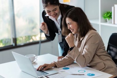 Modern bir ofiste başarılı bir projeyi kutlayan iki iş kadını takım çalışması ve profesyonel başarı sergilediler..