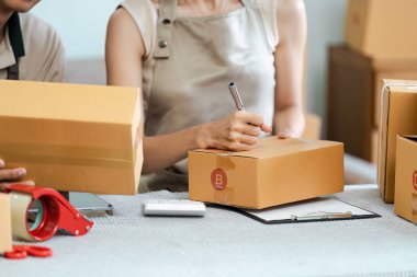 Girişimciler e-ticaret taşımacılığı için paketler hazırlıyorlar, modern çevrimiçi iş operasyonlarının dinamik ve verimli doğasını sergiliyorlar.